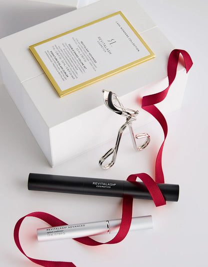 Revitalash cosmetic products with a white box and red ribbon on a light gray background