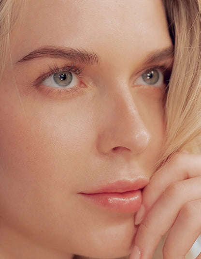 Close-up of a person with light skin and blonde hair, wearing a white shirt.