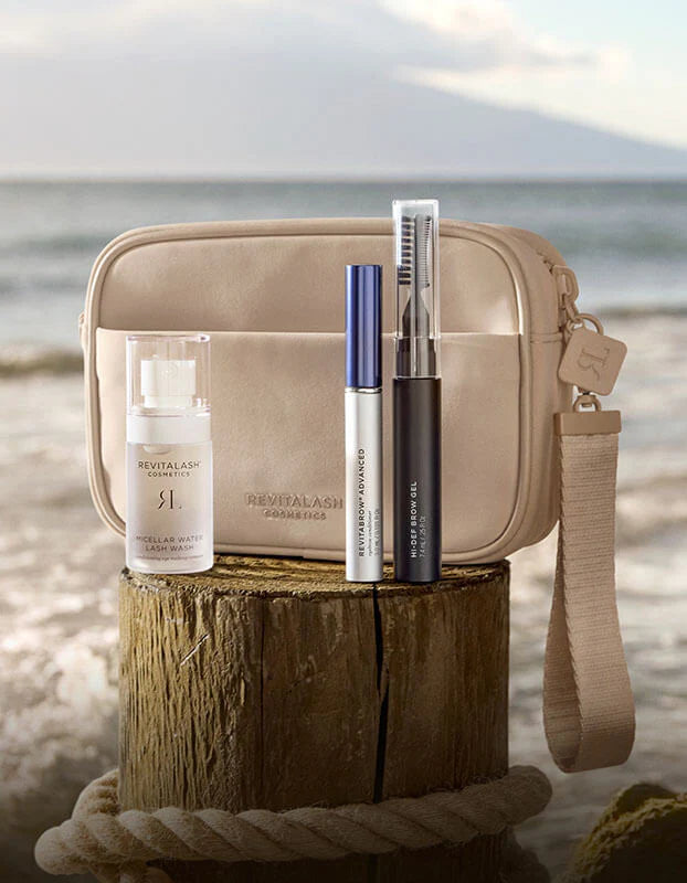 Revitalash Cosmetics | Strengthen &amp; Define Brow Collection with Cosmetic bag with skincare products on a wooden block by a beach