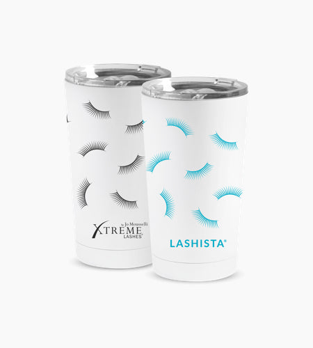 Two white insulated travel tumblers with clear lids, printed with eyelash designs. The left tumbler features black eyelashes and the text &